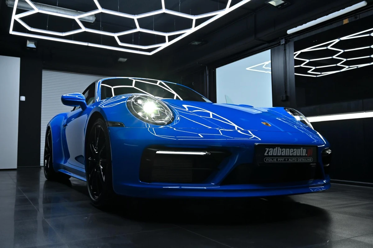 Niebieskie Porsche w garażu pod geometrycznym oświetleniem